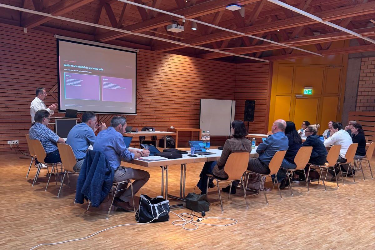 KI-Workshop an der Schule Entfelden: Teilnehmende an Tischen, vorne die Folie «Wofür KI sehr nützlich ist und wofür nicht»
